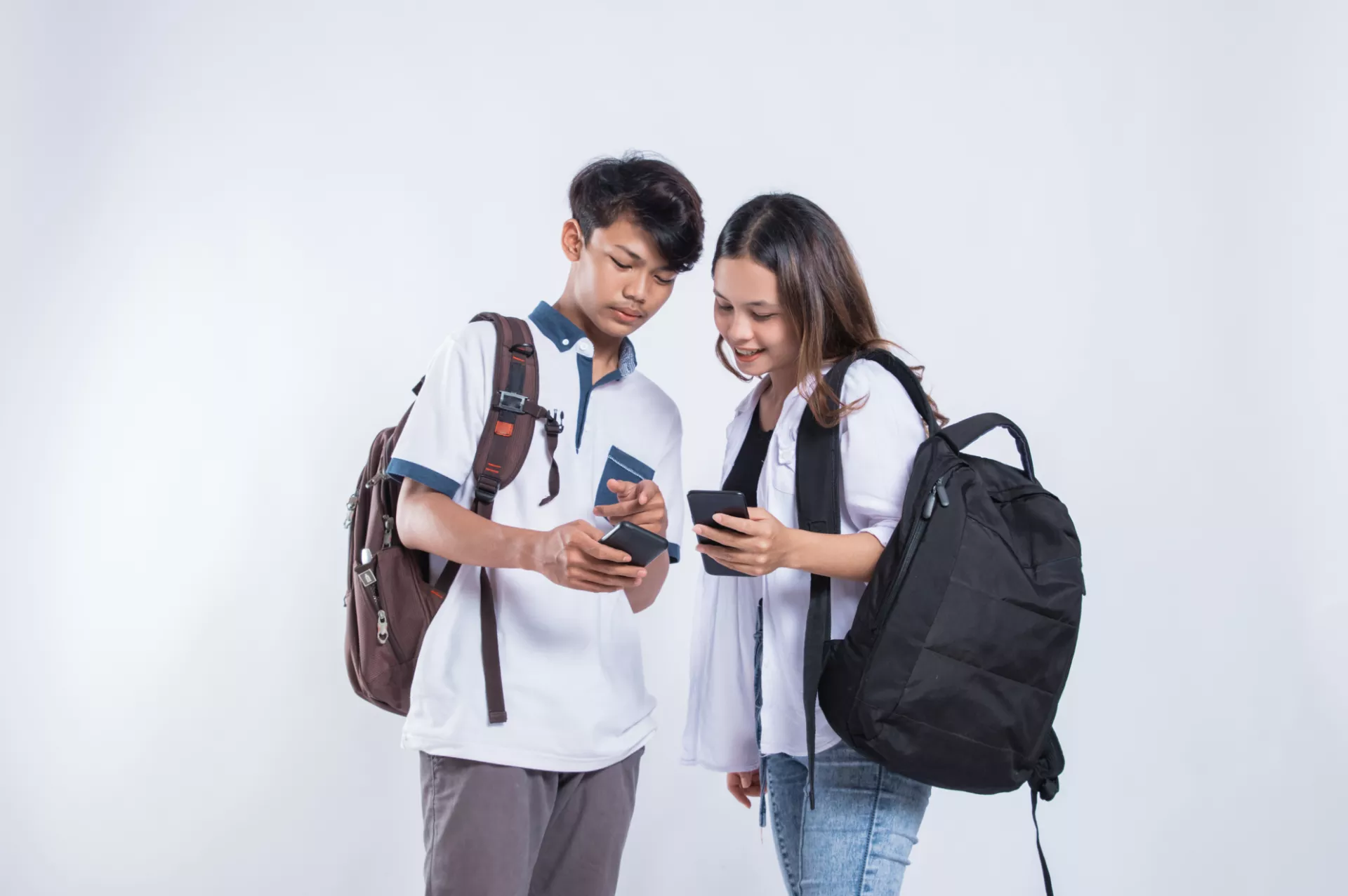 Two youth looking at their phones with the words "Contact Us" above.
